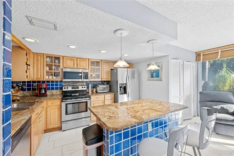 a living room with furniture a kitchen view and a chandelier