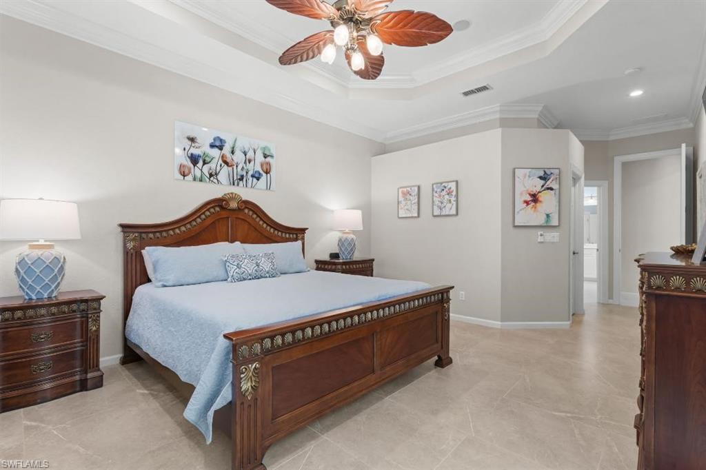 20117 Seadale Court Estero, FL 33928 - Photo 14 of 34 Tray ceiling with crown molding, ceiling fan, tile flooring, and solid wood bedroom furniture