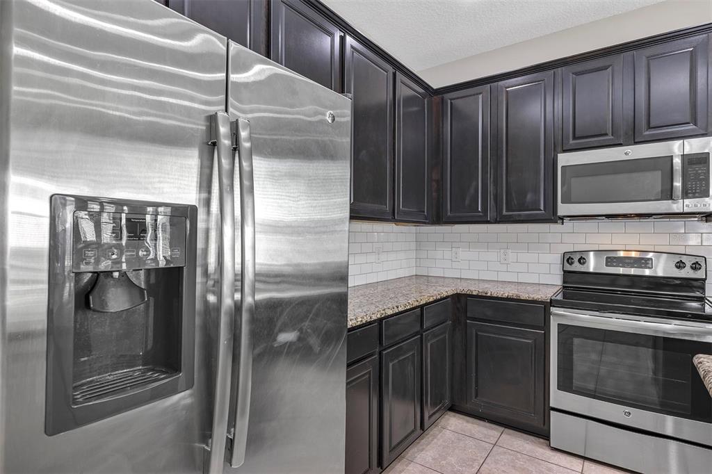 7644 Ripplepointe Way Windermere, FL 34786 - Photo 5 of 52 a kitchen with a refrigerator a stove and cabinets