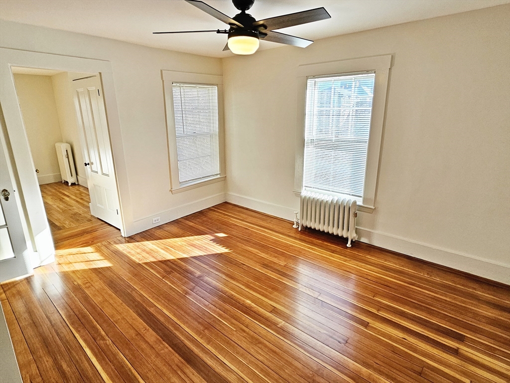 11 Channing Street, Unit 2 Newton, MA 02458 - Photo 12 of 27 an empty room with wooden floor fan and windows