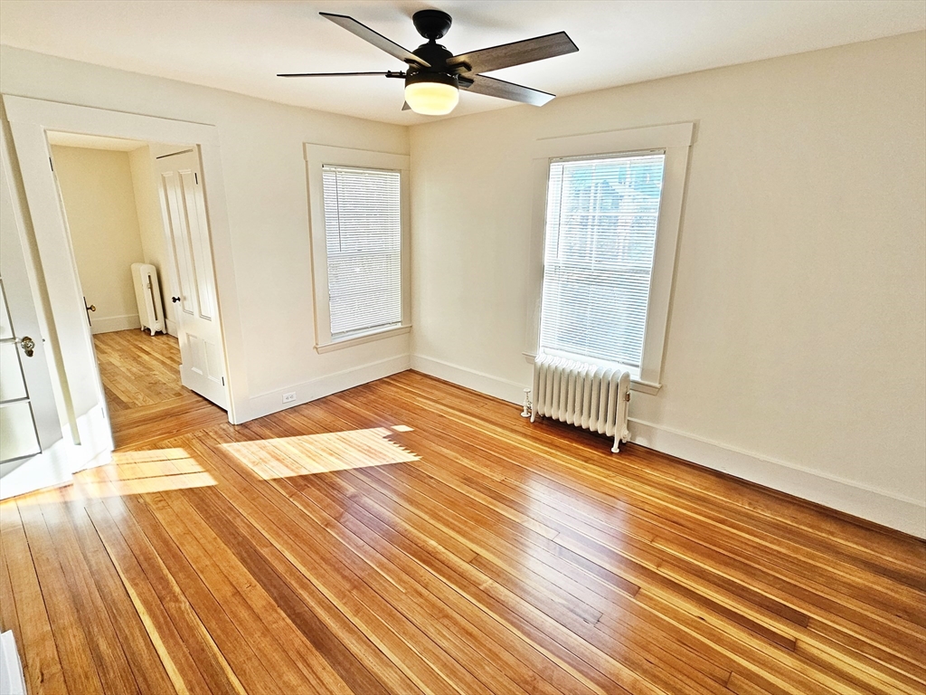 11 Channing Street, Unit 2 Newton, MA 02458 - Photo 18 of 27 an empty room with wooden floor fan and windows