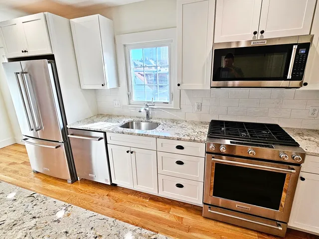 a kitchen with granite countertop a stove microwave and sink