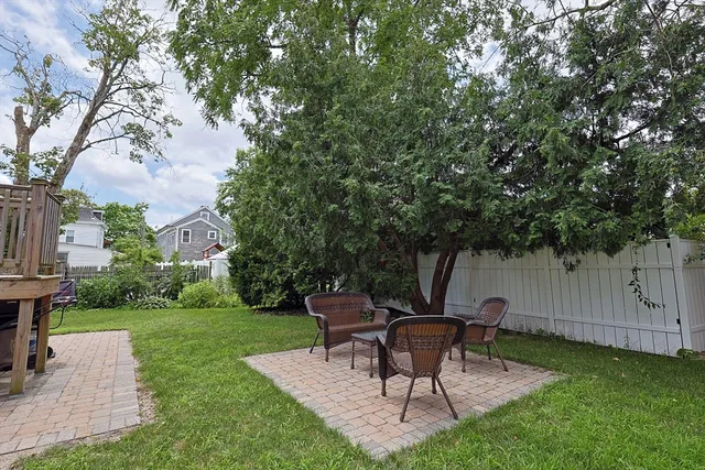 a backyard of a house with table and chairs
