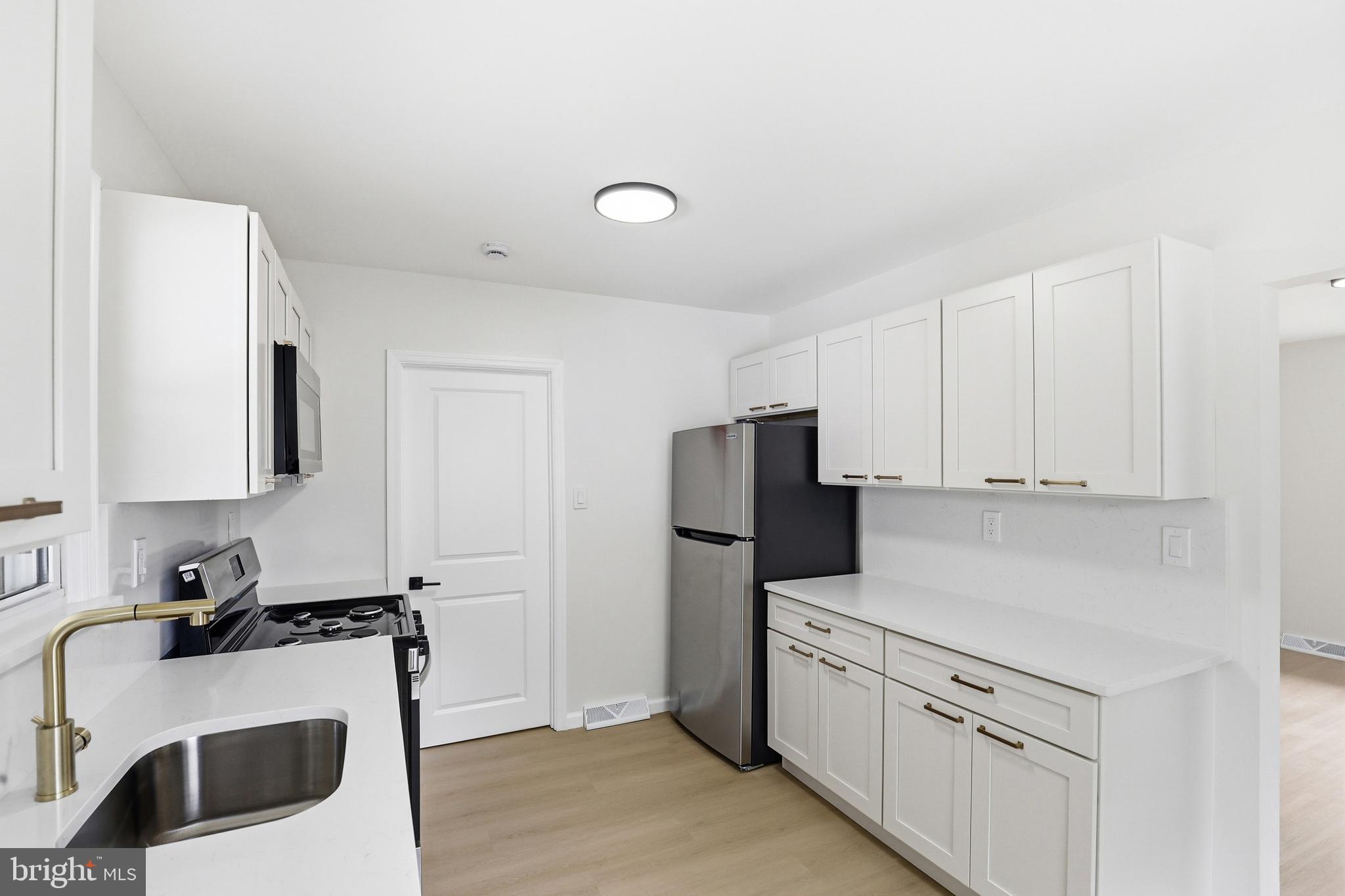 710 East Gibbsboro Road Lindenwold, NJ 08021 - Photo 12 of 21 a kitchen with a refrigerator sink and white cabinets