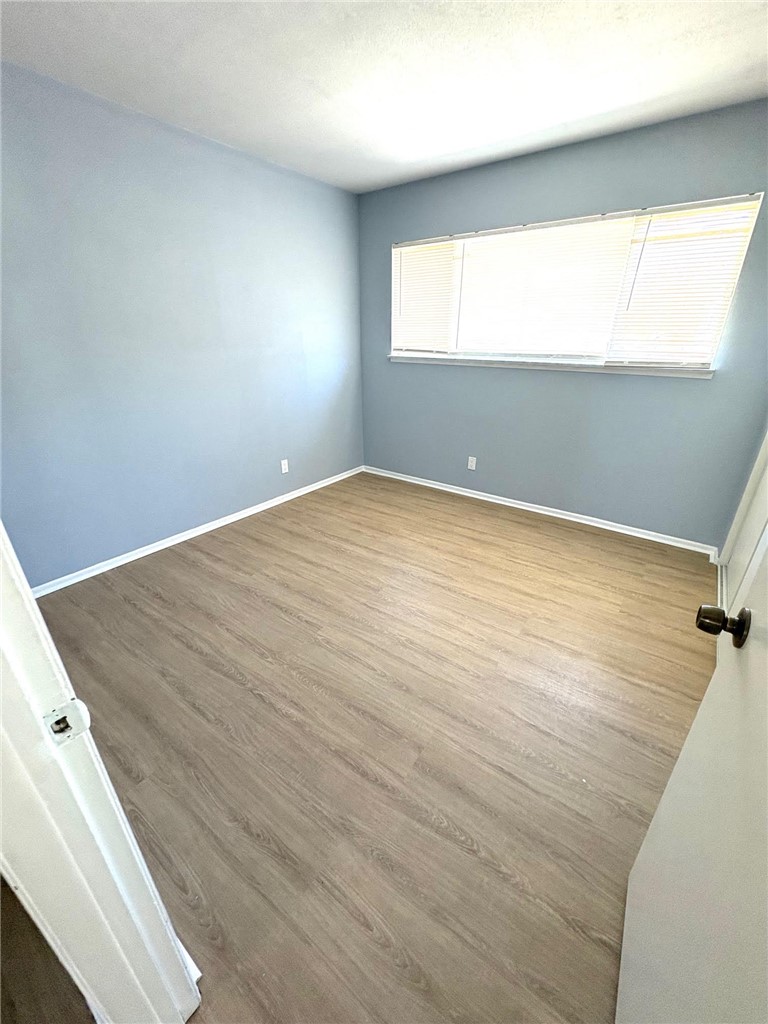 504 Heyer Street Lancaster, CA 93534 - Photo 5 of 8 an empty room with wooden floor and windows