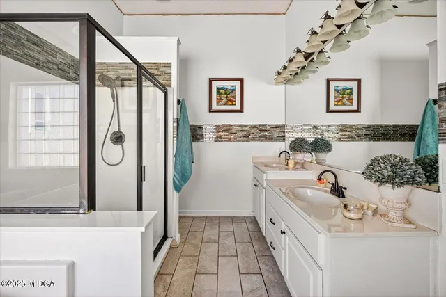 a bathroom with a granite countertop sink mirror vanity and bathtub