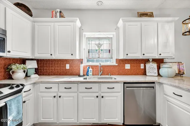 a kitchen with stainless steel appliances granite countertop a sink stove and cabinets