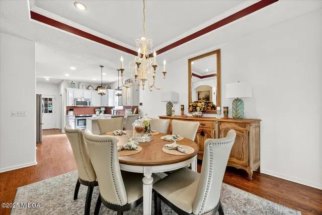 a view of a dining room with furniture and a chandelier