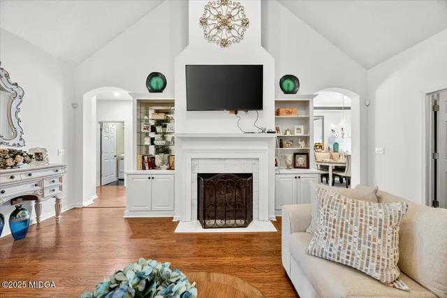 a living room with furniture a fireplace and a flat screen tv