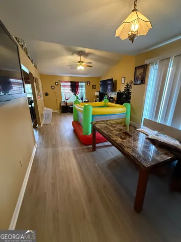 a room with wooden floor pool table and windows