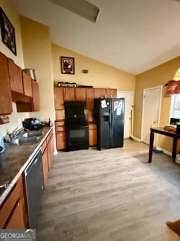 a kitchen with stainless steel appliances kitchen island granite countertop a refrigerator and a stove top oven