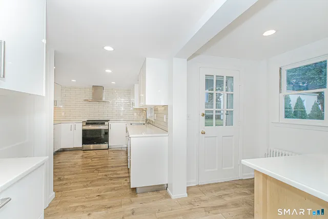 a kitchen with a refrigerator and a stove top oven