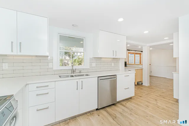 a kitchen with white cabinets appliances and a sink