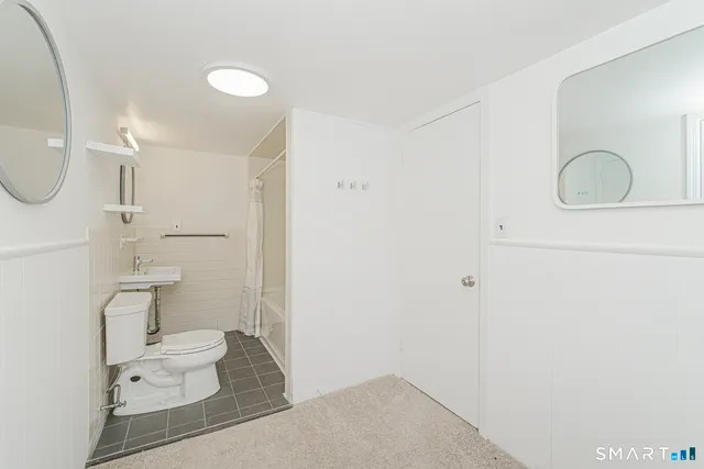 a bathroom with a toilet sink and mirror