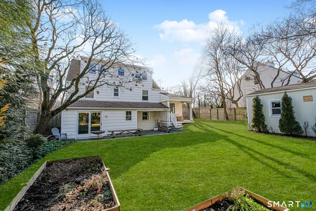 a view of a house with a yard and large trees