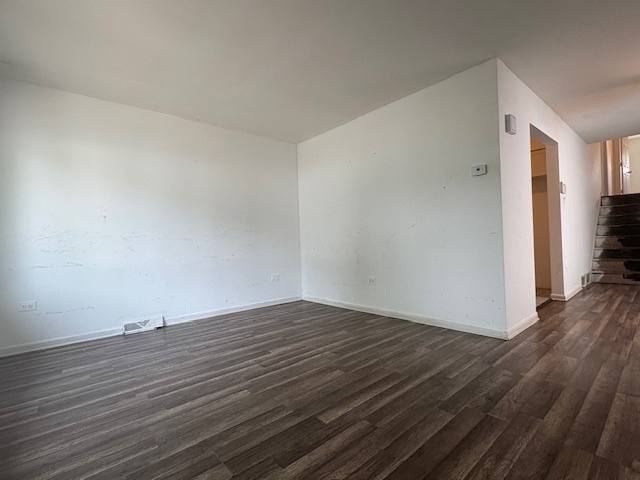 6542 South Carpenter Street Chicago, IL 60621 - Photo 2 of 17 a view of an empty room with wooden floor and a window
