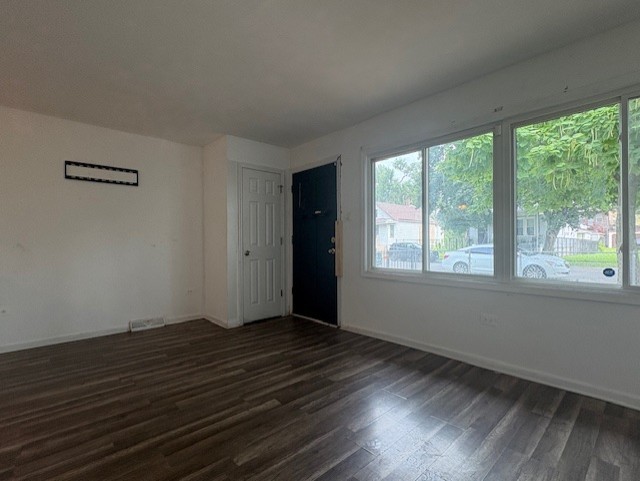 6542 South Carpenter Street Chicago, IL 60621 - Photo 3 of 17 a view of an empty room with wooden floor and a window
