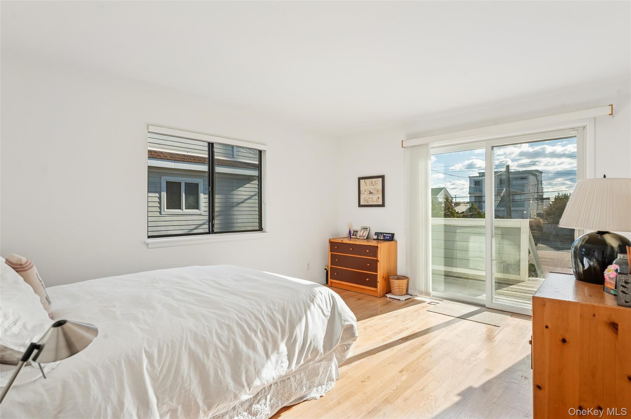 630 Dune Road Westhampton, NY 11978 - Photo 8 of 14 a bedroom with a bed and wooden floor