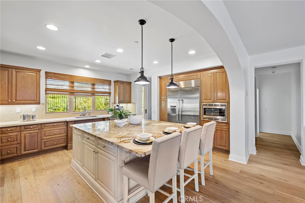 10 Gaucho Road Ladera Ranch, CA 92694 - Photo 10 of 52 a kitchen with a large window wooden floor and stainless steel appliances