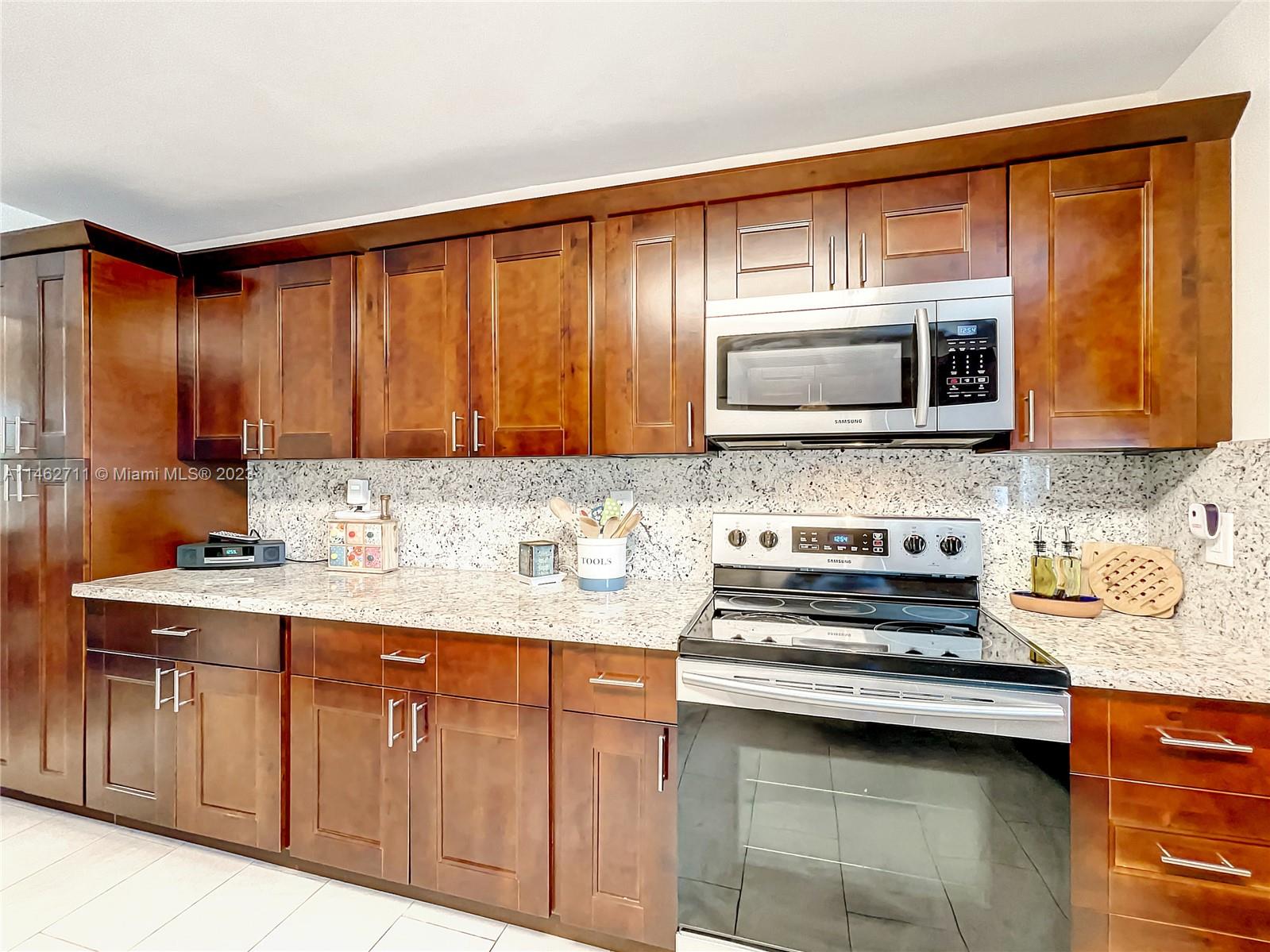 9035 Southwest 48th Terrace Miami, FL 33165 - Photo 11 of 37 a kitchen with stainless steel appliances granite countertop a sink stove and microwave