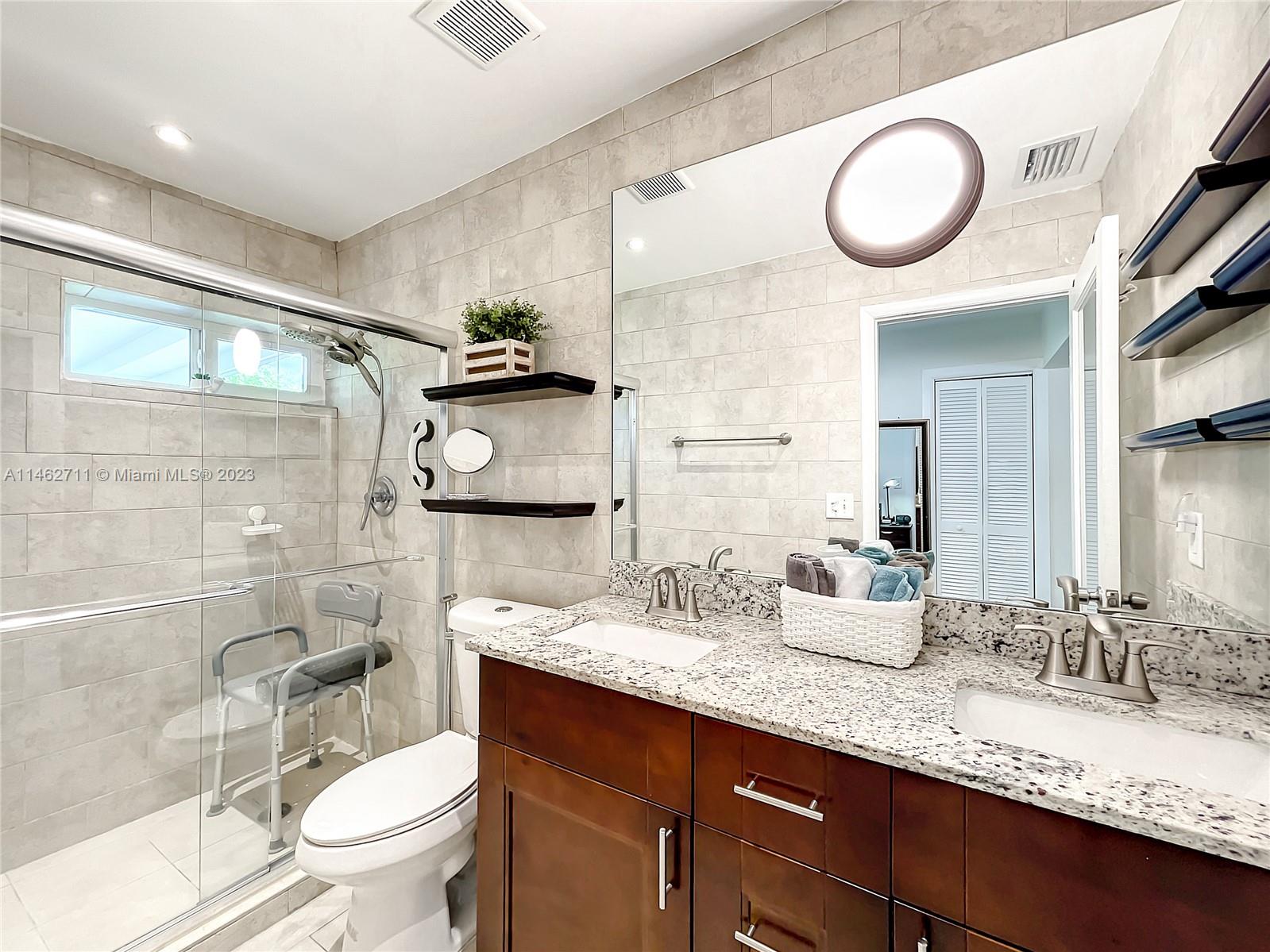 9035 Southwest 48th Terrace Miami, FL 33165 - Photo 22 of 37 a bathroom with a granite countertop sink mirror vanity and toilet
