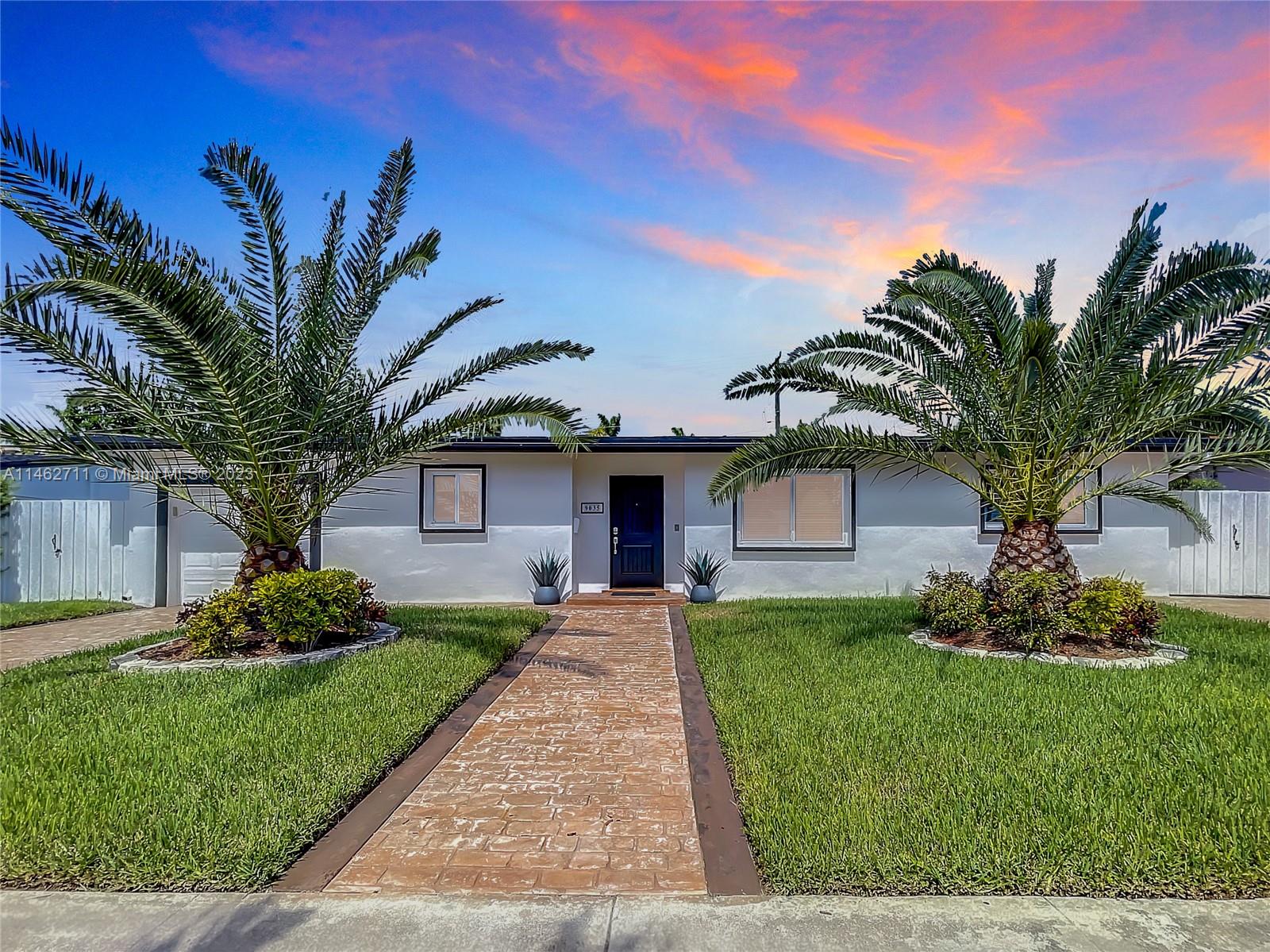 9035 Southwest 48th Terrace Miami, FL 33165 - Photo 29 of 37 a front view of a house with a garden and trees