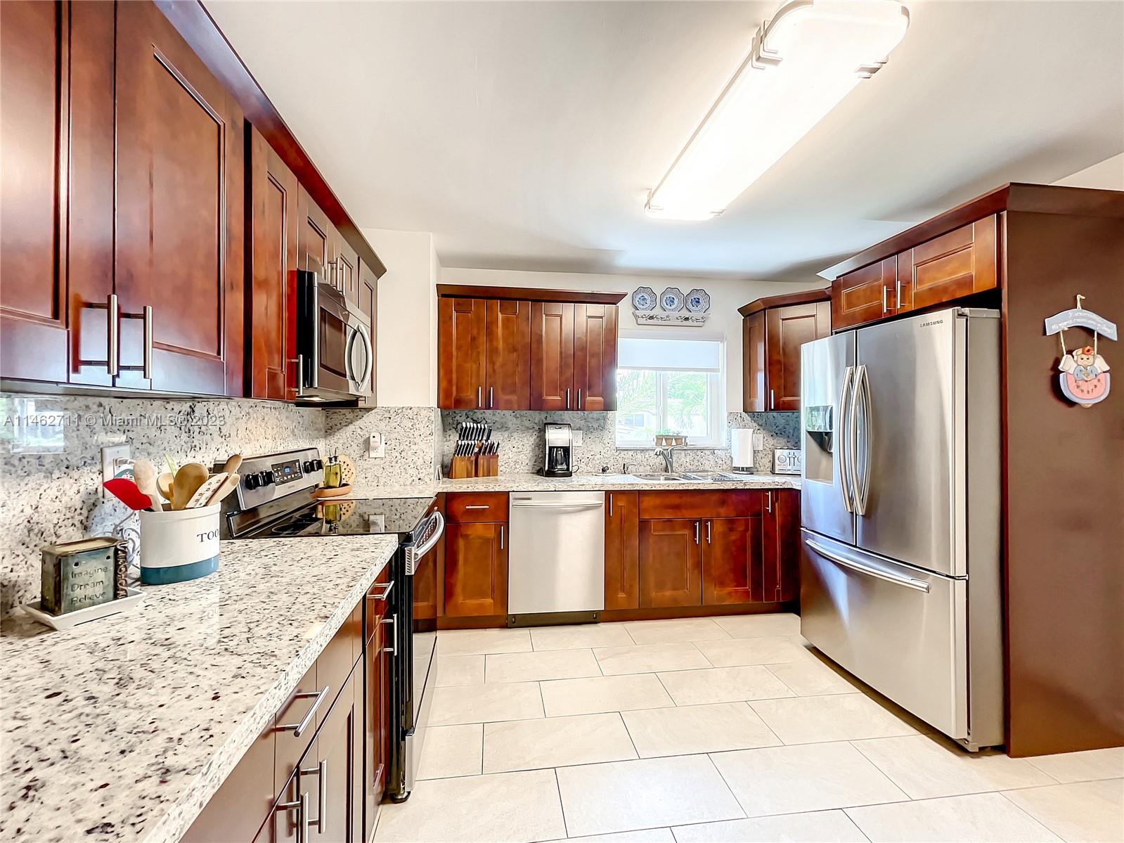 9035 Southwest 48th Terrace Miami, FL 33165 - Photo 9 of 37 a kitchen with stainless steel appliances granite countertop a refrigerator sink and cabinets