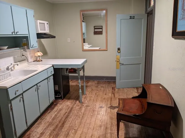 a kitchen with sink cabinets and wooden floor