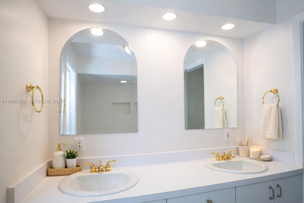 400 St Andrews Road, Unit 56 Hollywood, FL 33021 - Photo 15 of 18 a bathroom with a double vanity sink and a mirror