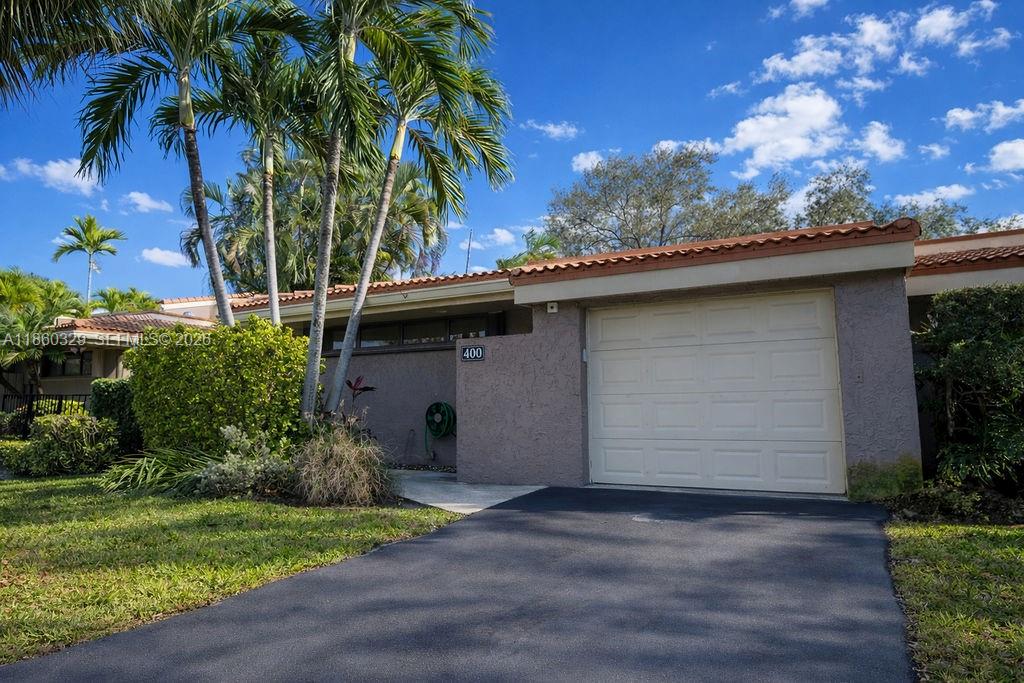 400 St Andrews Road, Unit 56 Hollywood, FL 33021 - Photo 2 of 18 a backyard of a house with plants and palm tree