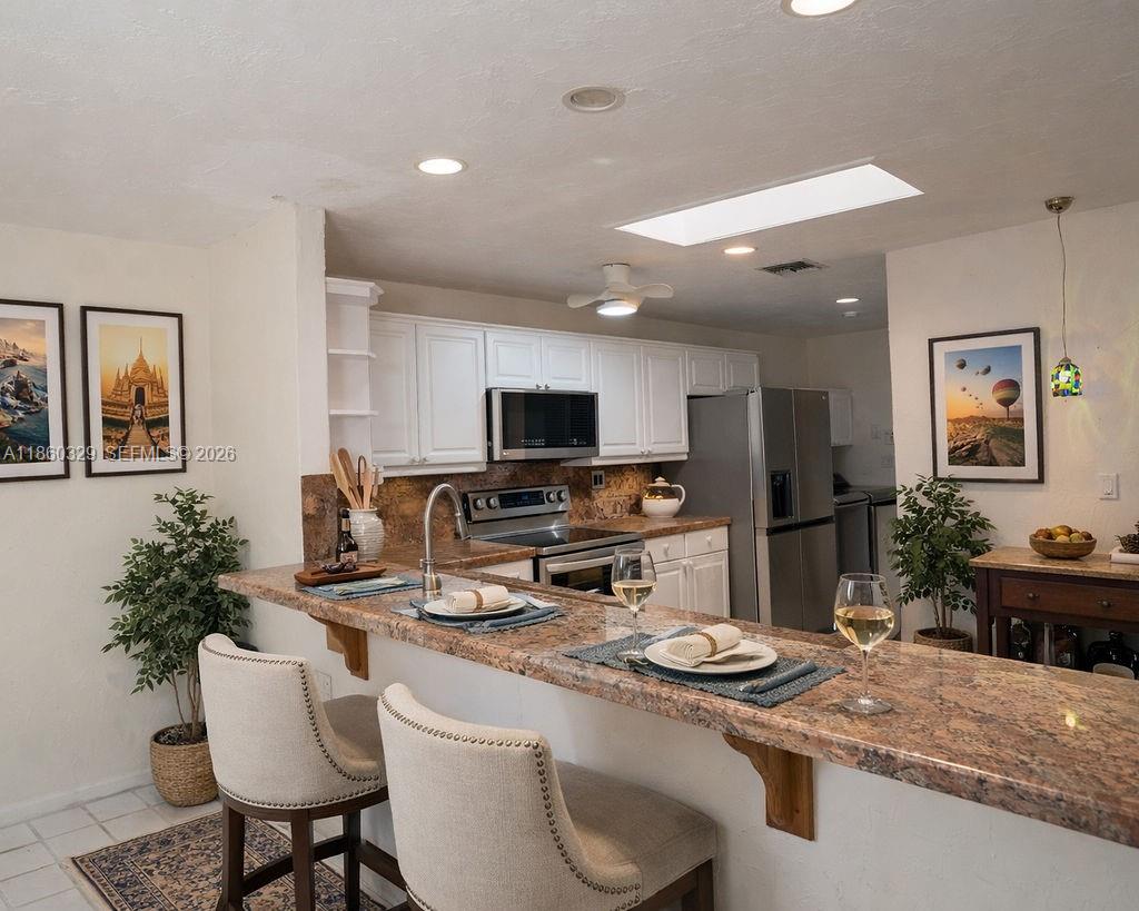 400 St Andrews Road, Unit 56 Hollywood, FL 33021 - Photo 5 of 18 a kitchen with a refrigerator and a stove top oven
