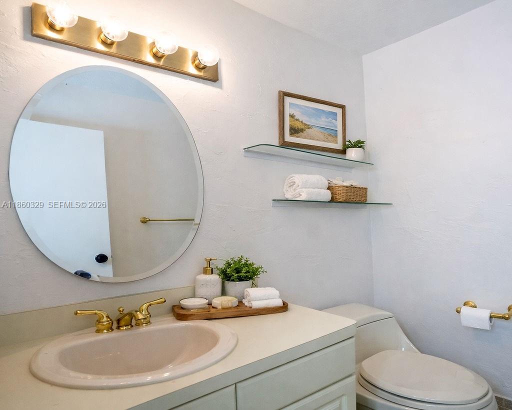 400 St Andrews Road, Unit 56 Hollywood, FL 33021 - Photo 10 of 18 a bathroom with a toilet sink and mirror