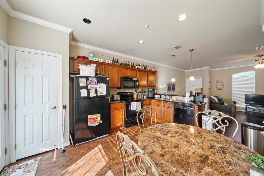 1198 Jones-Butler Road, Unit 203 College Station, TX 77840 - Photo 6 of 18 Kitchen featuring crown molding, black appliances, dark countertops, hanging light fixtures, and brown cabinets