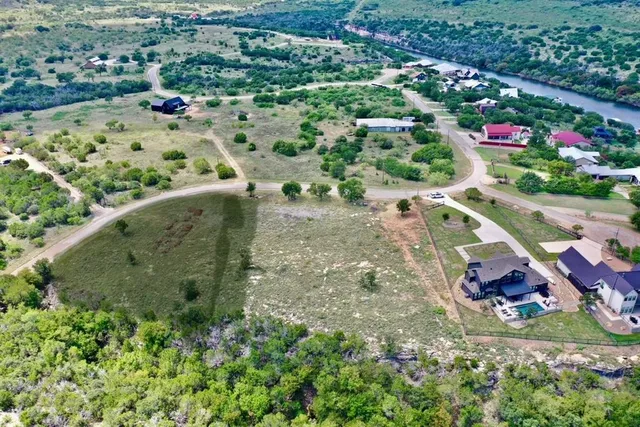 an aerial view of residential houses with outdoor space and trees
