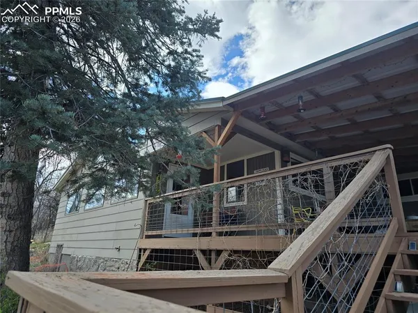 a roof deck with wooden floor and stairs
