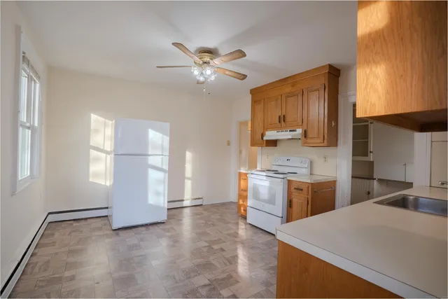 a kitchen with a refrigerator a stove top oven and a sink