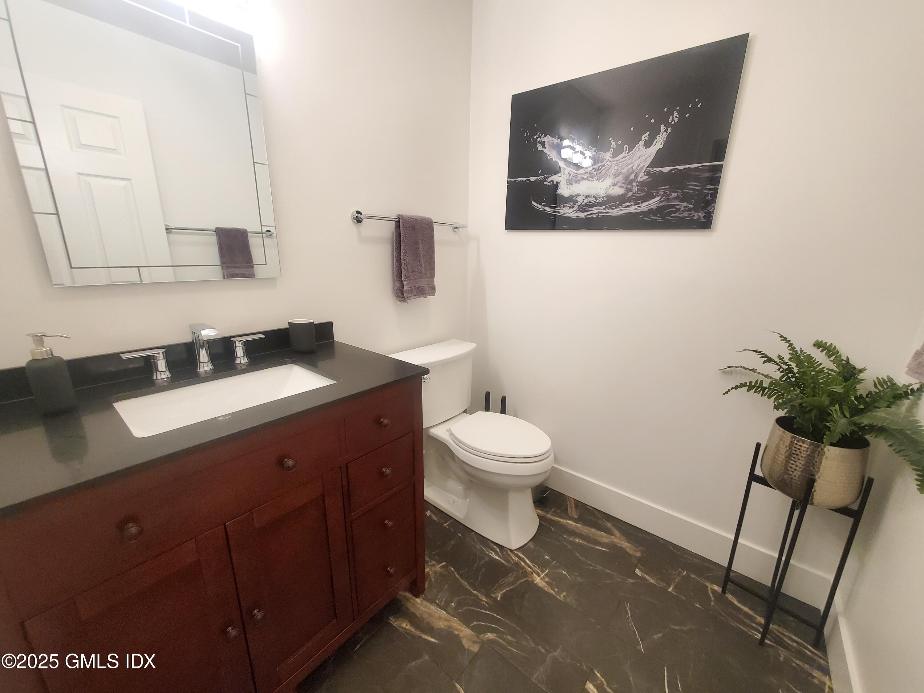 92 Valley Road, Unit A Cos Cob, CT 06807 - Photo 12 of 57 a spacious bathroom with a toilet a sink and mirror