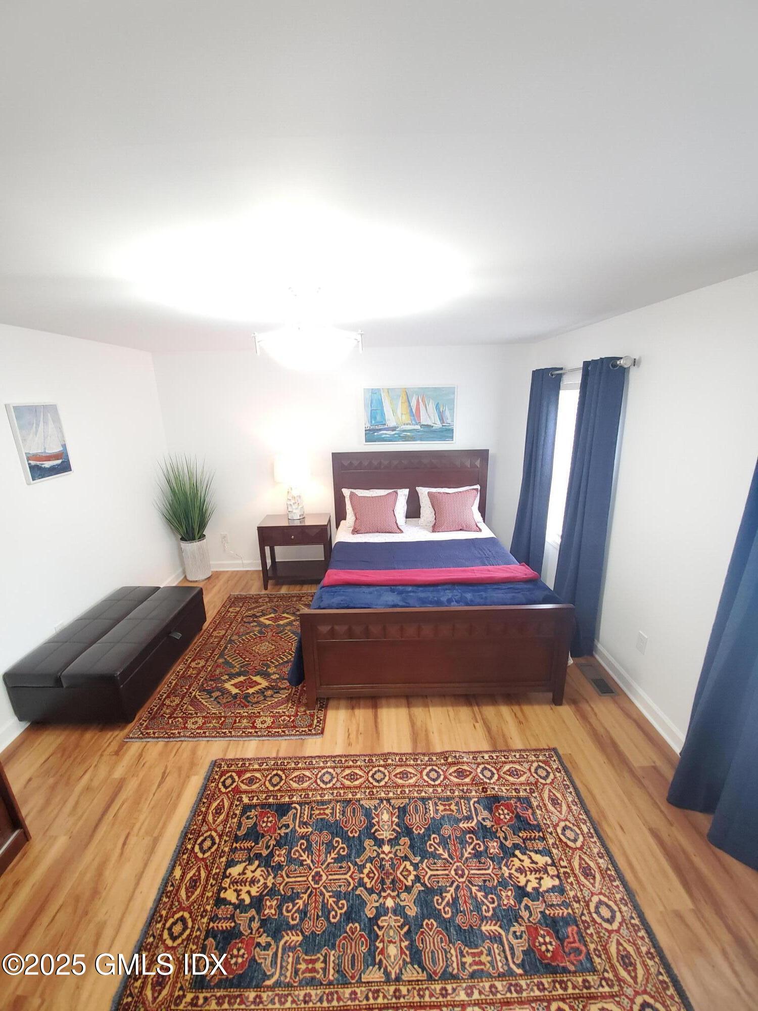 92 Valley Road, Unit A Cos Cob, CT 06807 - Photo 16 of 57 a bedroom with a bed and wooden floor