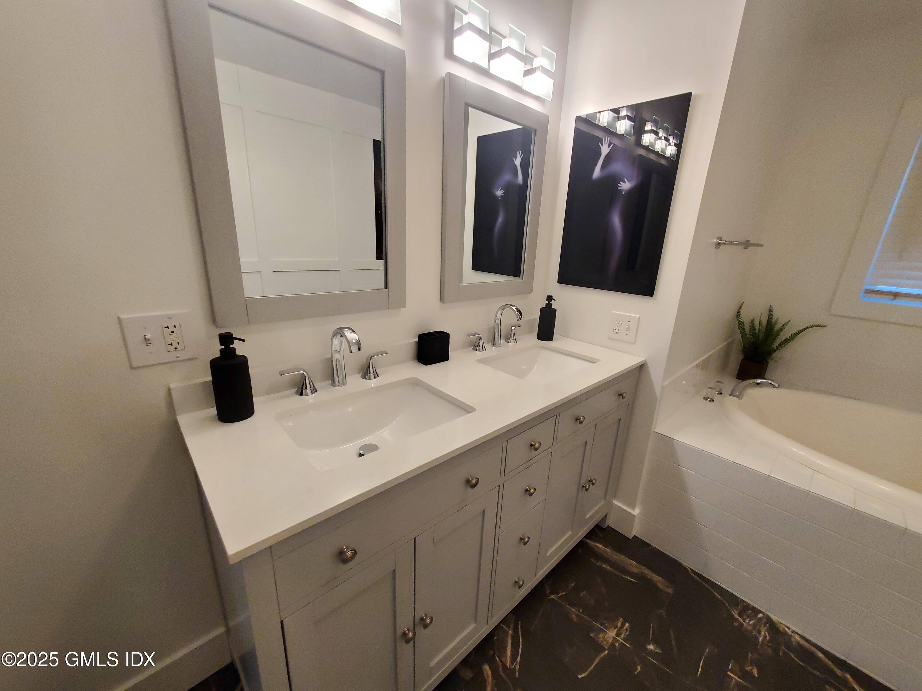 92 Valley Road, Unit A Cos Cob, CT 06807 - Photo 26 of 57 a bathroom with a double vanity sink mirror and bathtub