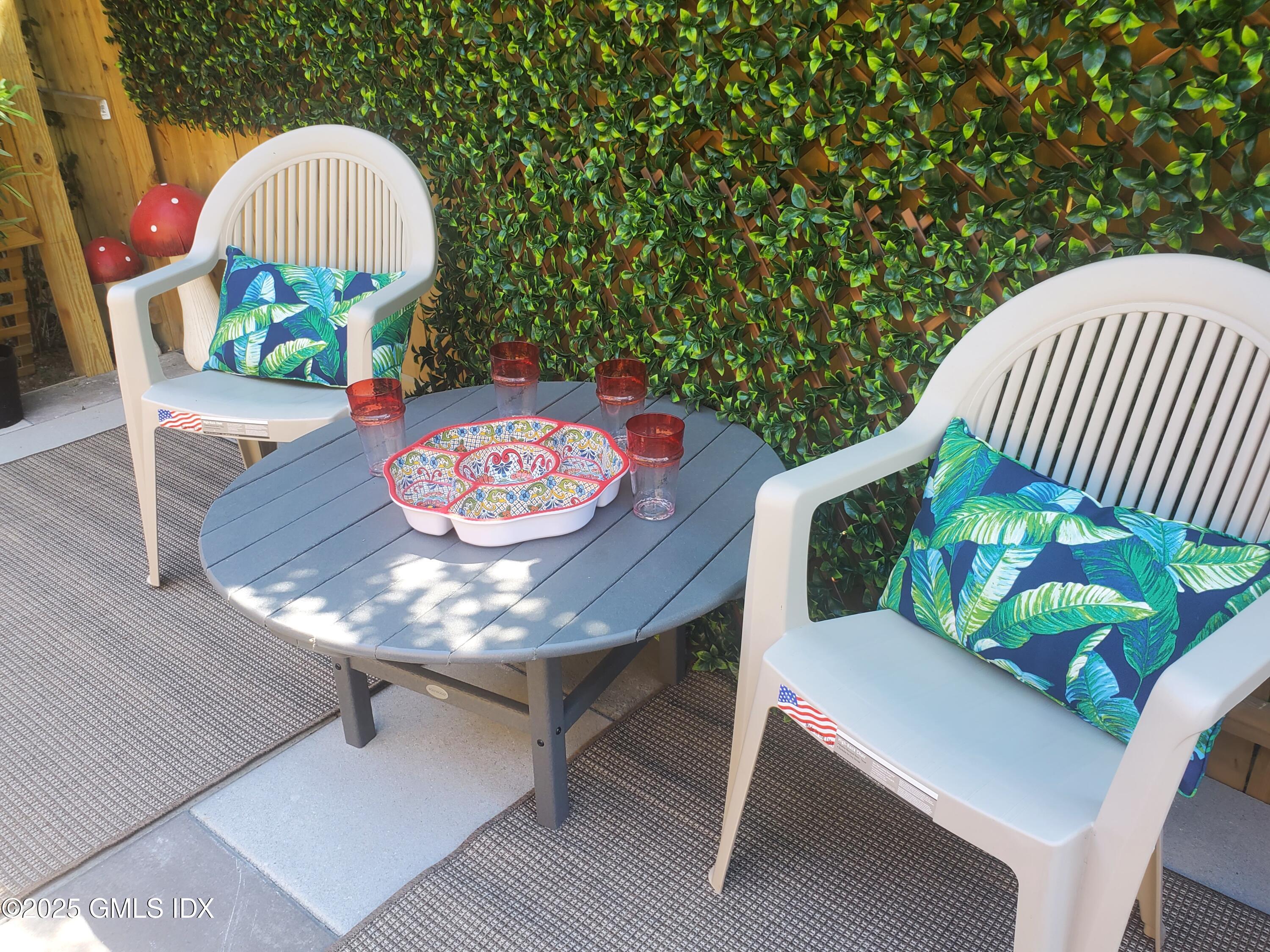 92 Valley Road, Unit A Cos Cob, CT 06807 - Photo 44 of 57 a table with chairs and a vase of flowers sitting on a table