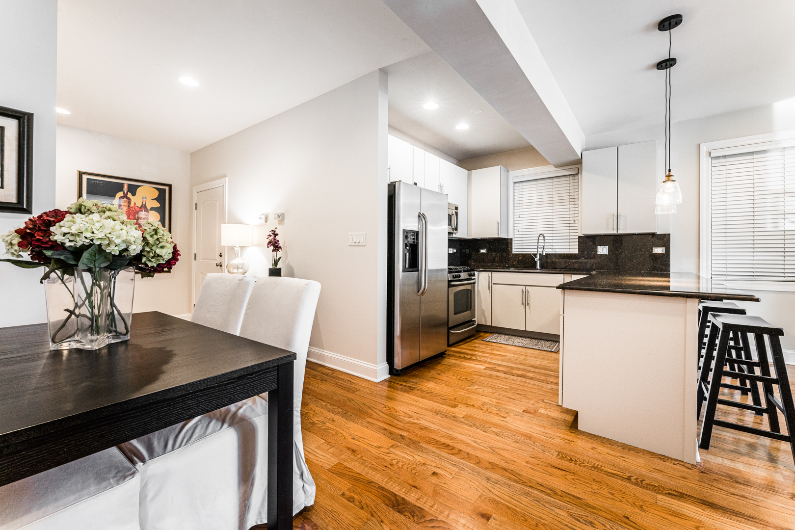 844 West Erie Street, Unit 1 Chicago, IL 60642 - Photo 11 of 37 a kitchen with stainless steel appliances a dining table chairs refrigerator and sink