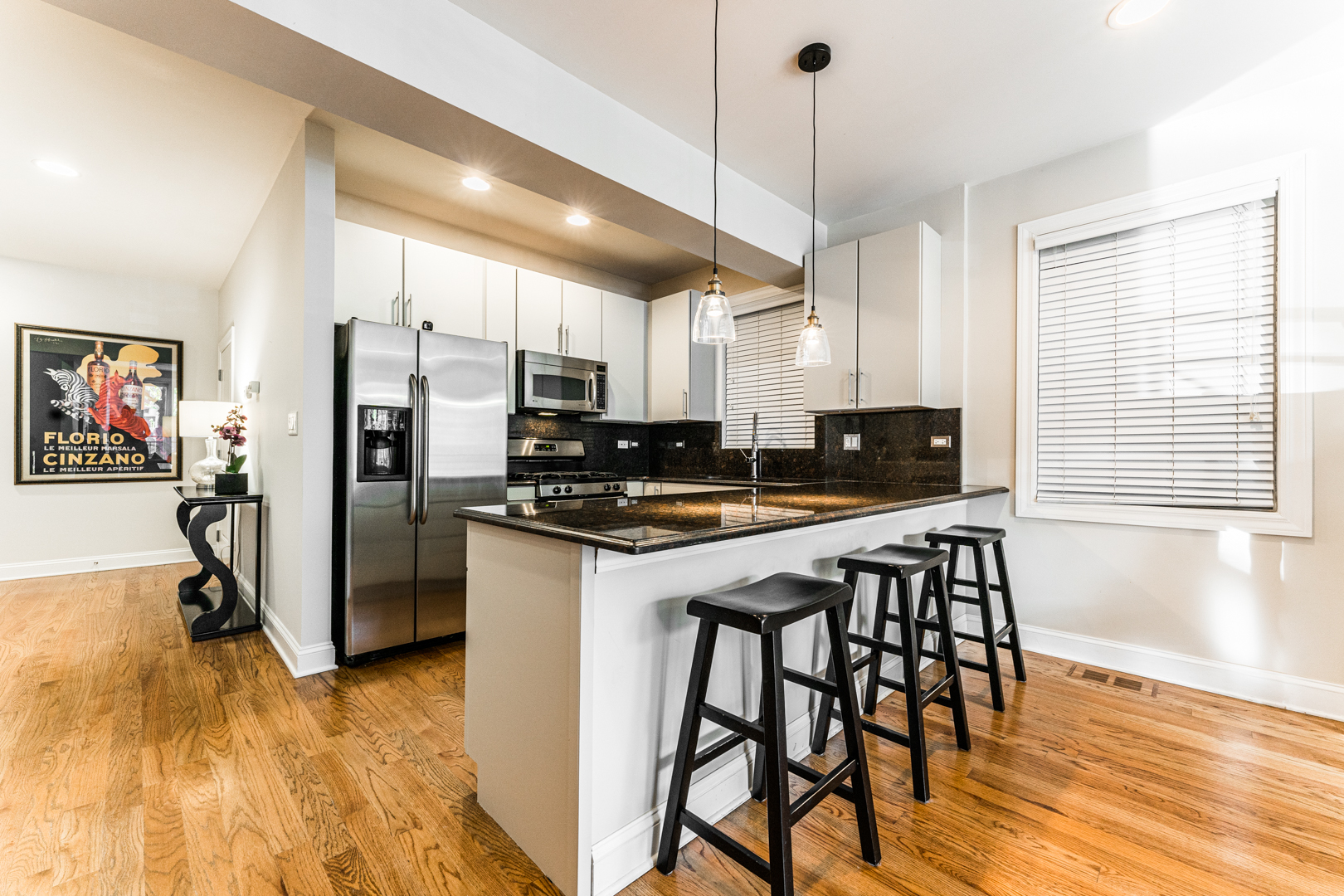 844 West Erie Street, Unit 1 Chicago, IL 60642 - Photo 8 of 37 a kitchen with stainless steel appliances granite countertop a stove a refrigerator a sink a dining table and chairs with wooden floor