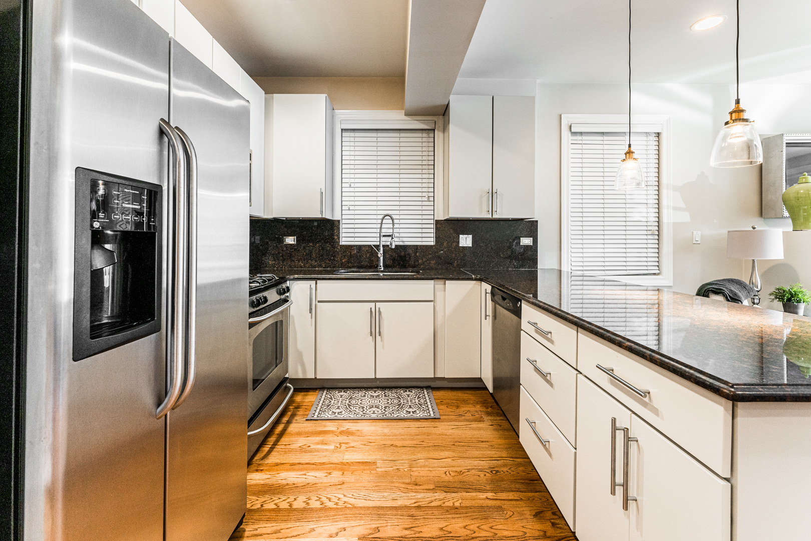 844 West Erie Street, Unit 1 Chicago, IL 60642 - Photo 9 of 37 a large white kitchen with stainless steel appliances granite countertop a refrigerator a sink and white cabinets
