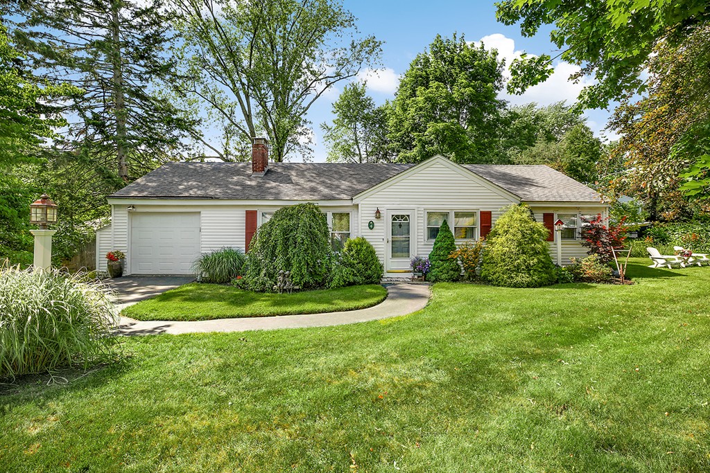 a front view of a house with a yard and trees