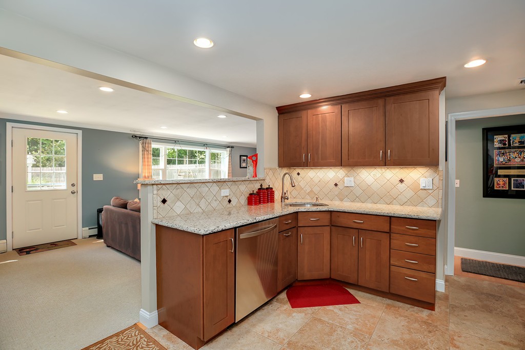 4 Beaconsfield Drive Natick, MA 01760 - Photo 8 of 22 a kitchen with stainless steel appliances granite countertop a sink and dishwasher a stove with wooden cabinets