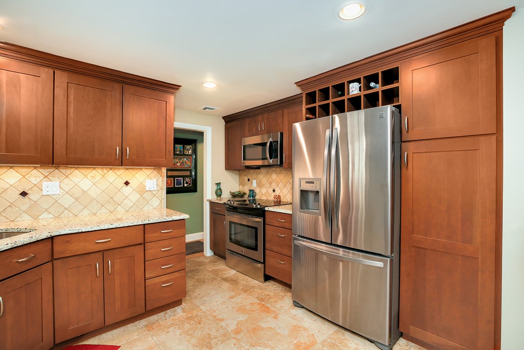 4 Beaconsfield Drive Natick, MA 01760 - Photo 9 of 22 a kitchen with stainless steel appliances granite countertop a refrigerator and a stove top oven