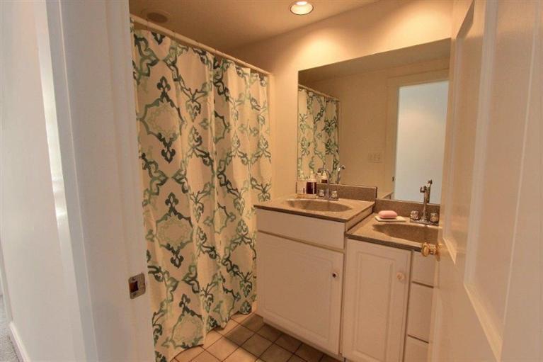 149 Leeward Road Bourne, MA 02532 - Photo 18 of 35 a bathroom with a granite countertop sink a mirror a vanity and a shower