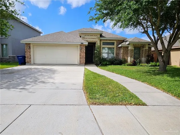 a front view of a house with a garden and trees