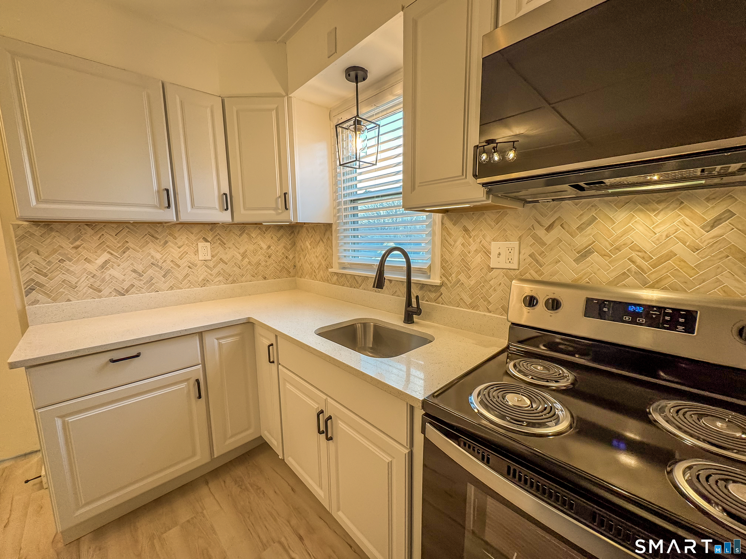 a kitchen with a stove and white cabinets