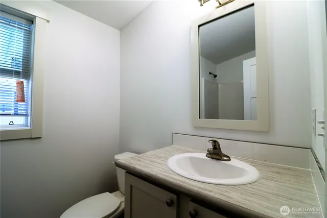a bathroom with a toilet sink and mirror